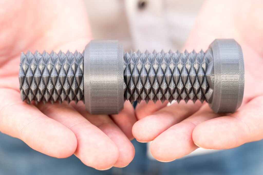 3D printed bolt with bi-directional thread in male hands close-up